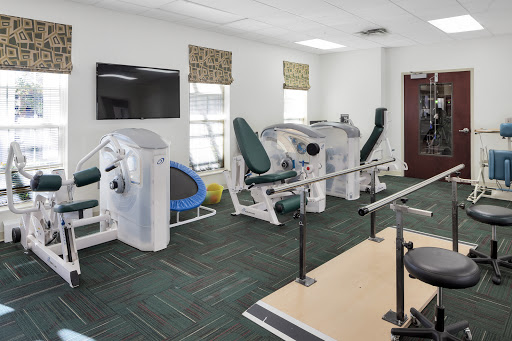 A well-equipped rehabilitation gym featuring various exercise machines for physical therapy.