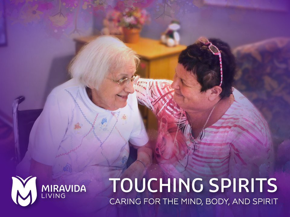 Two women enjoying a joyful moment together at a care facility.