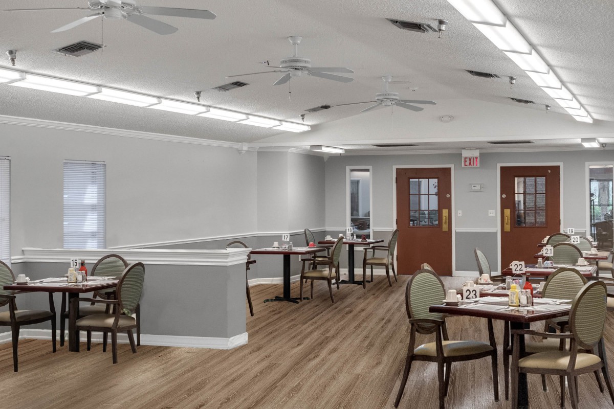 An empty dining area with modern furnishings and soft lighting.