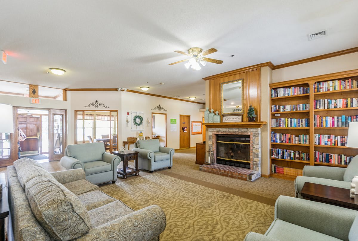 A cozy living room featuring a fireplace, comfortable seating, and a bookshelf.