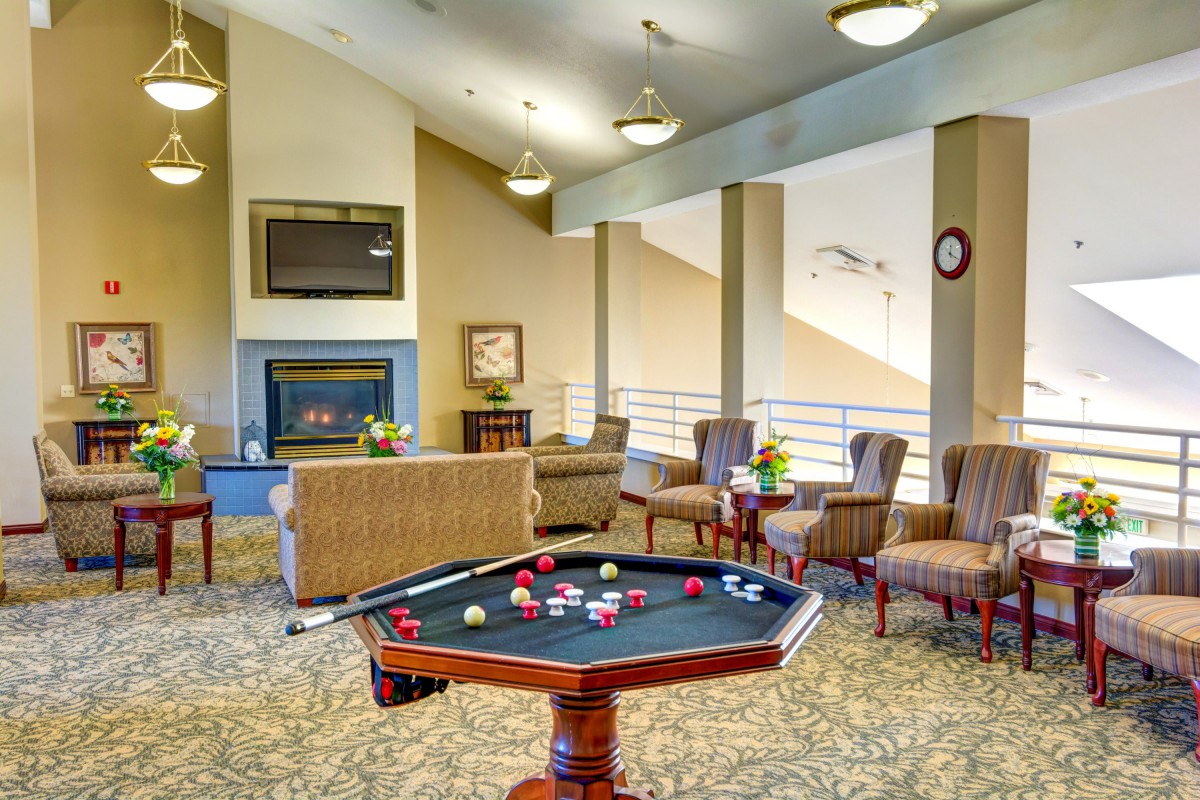 A cozy lounge area featuring a pool table and comfortable seating arrangements.