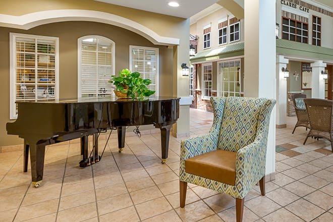 A well-furnished lobby featuring a grand piano and an elegant armchair.