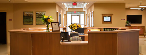 A welcoming reception area featuring a desk, flowers, and a bright entrance.