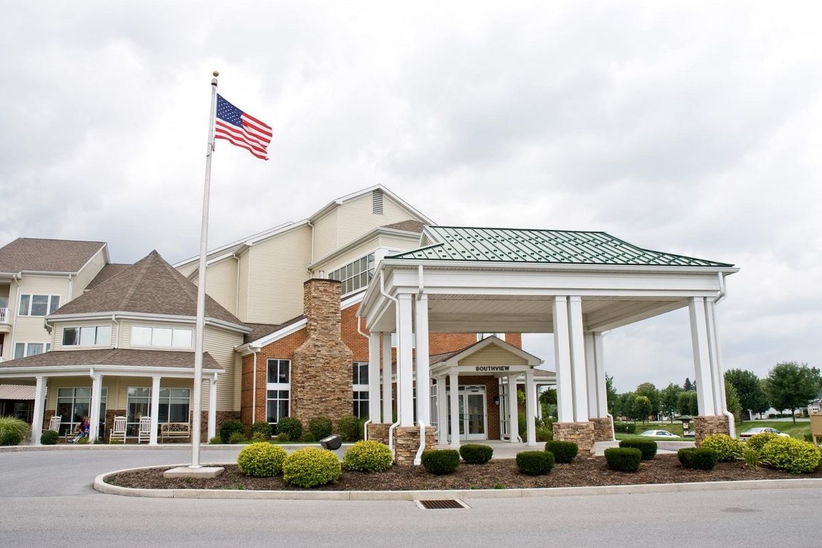 A hotel entrance with an American flag flying outside.