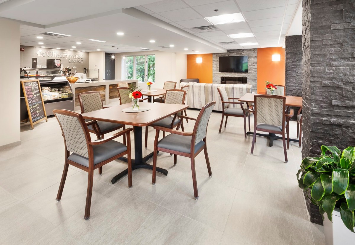 A modern dining area with neatly arranged tables and chairs, featuring a warm and inviting atmosphere.
