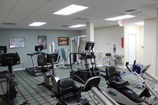 A well-equipped indoor gym featuring various exercise machines for cardiovascular workouts.