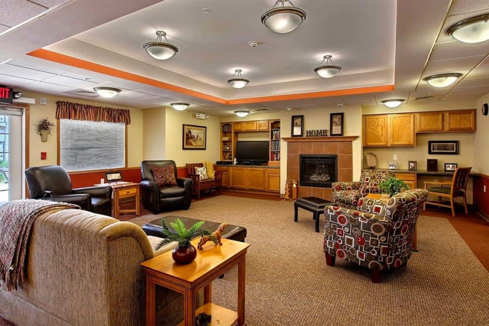 A cozy living room with comfortable seating, a fireplace, and a television.