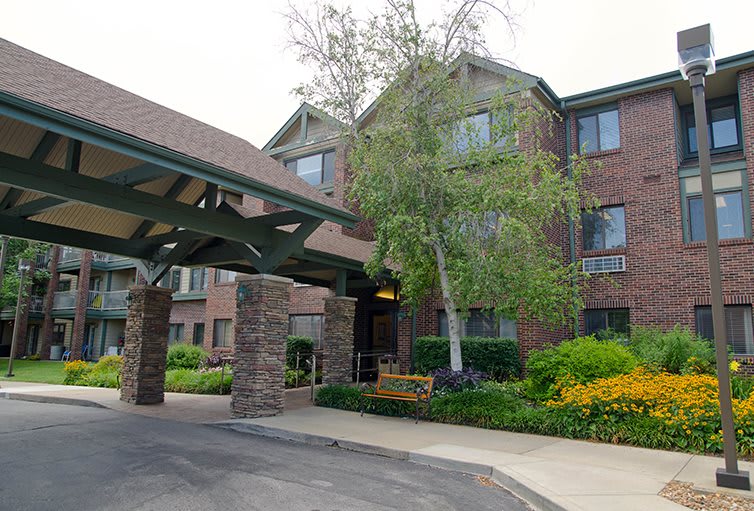 A well-maintained brick building with a covered entrance and lush landscaping.