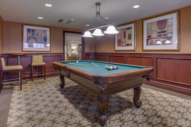 A cozy game room featuring a classic billiard table under stylish lighting.