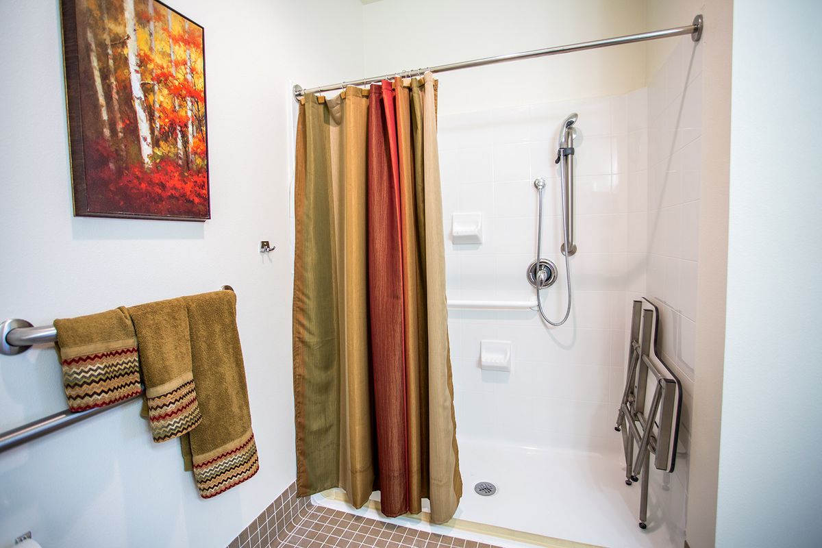 A cozy bathroom with a colorful shower curtain and matching towels.