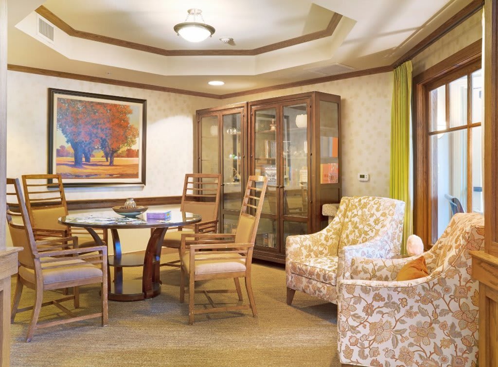 A cozy living room with a seating area, featuring elegant furniture and decorative artwork.