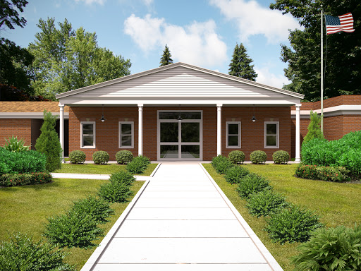 A welcoming facade of a modern building surrounded by greenery.