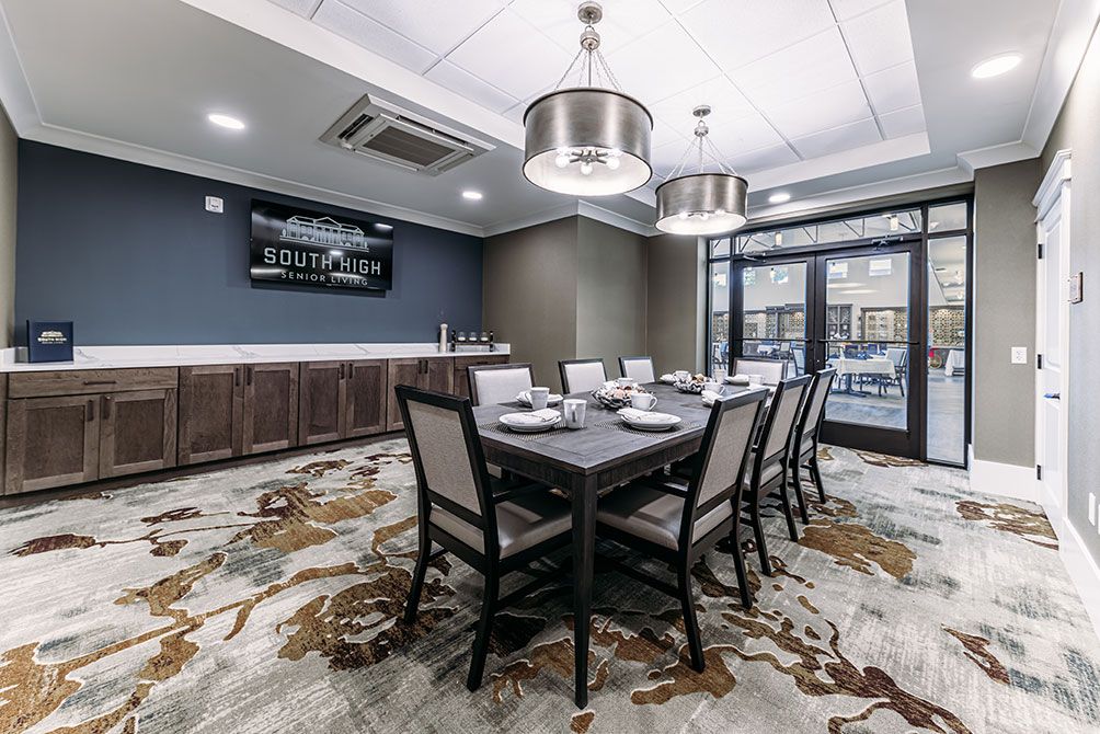 A modern dining room with a large table and elegant chairs, featuring stylish lighting and decor.