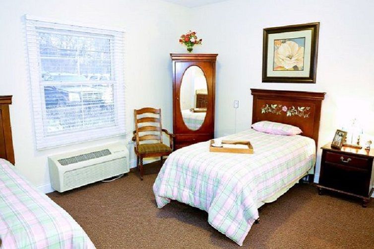 A cozy bedroom with a single bed, wooden furniture, and decorative elements.
