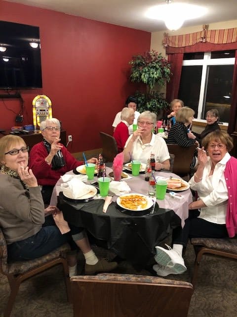 A group of friends enjoying a meal together in a cozy indoor setting.