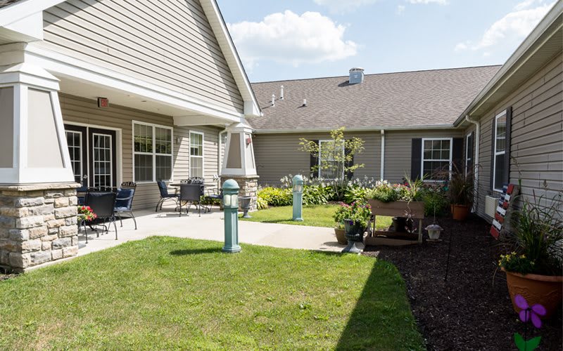 A well-maintained courtyard with greenery and outdoor seating adjacent to a residential building.