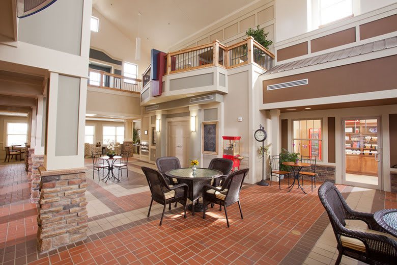 A spacious interior with a seating area, balcony, and decorative plants.