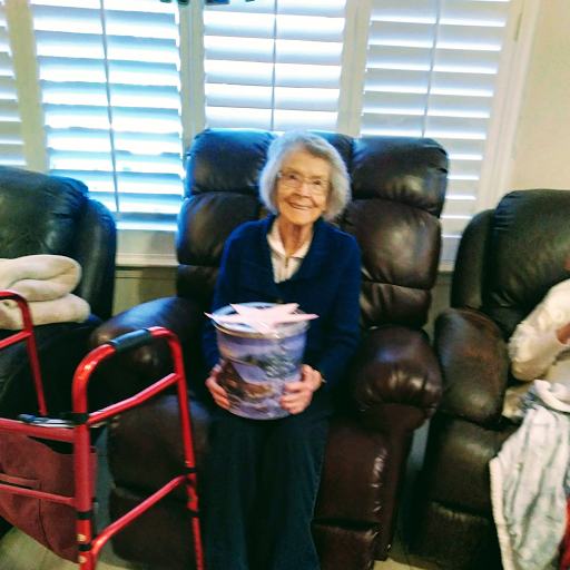 An elderly woman enjoying time with family in a cozy living room.
