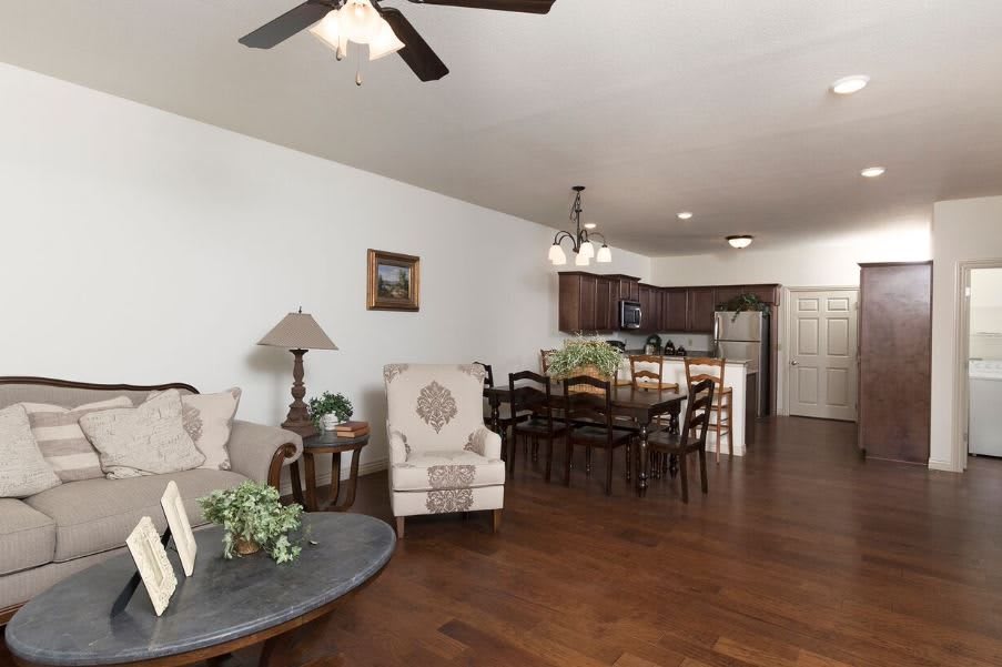 An open-concept living and dining area with hardwood floors and a view into the kitchen.