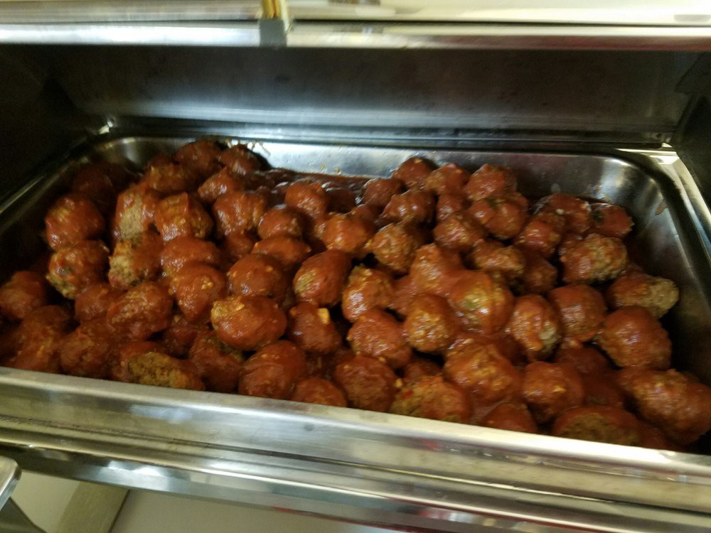 A large tray of meatballs served in a buffet setting.
