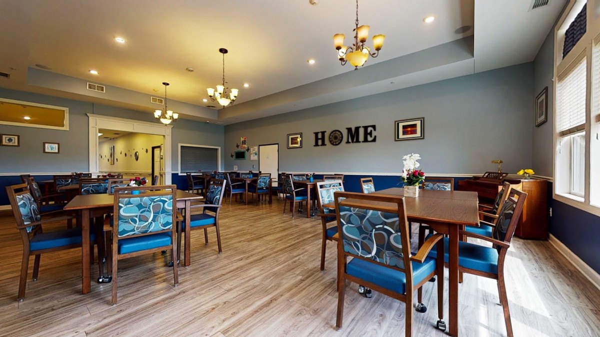 A cozy dining room with elegant chandeliers and wooden flooring.