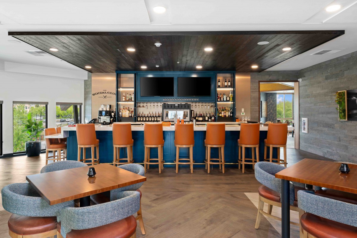 A modern bar and restaurant interior with a sleek counter and comfortable seating.