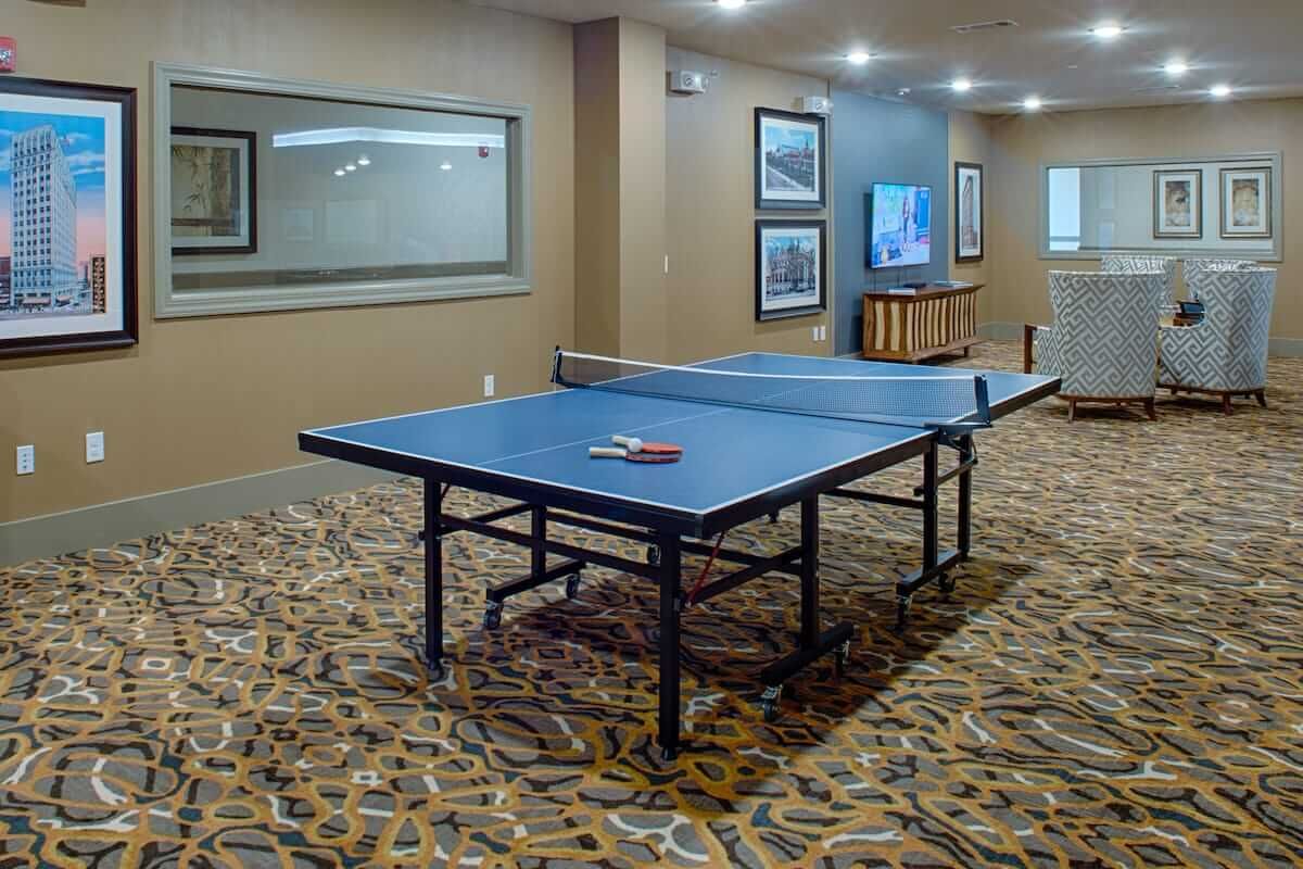 A recreation room featuring a ping pong table and a TV for indoor entertainment.