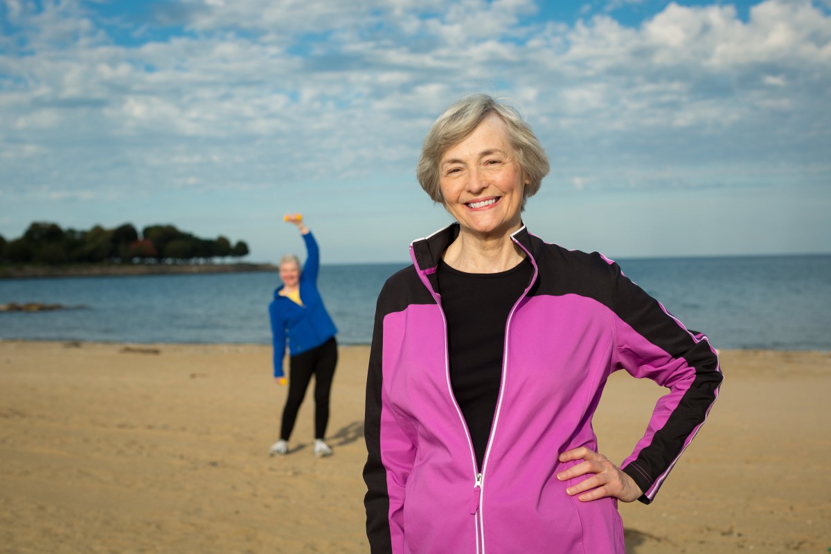 Two women enjoying exercise by the beach.