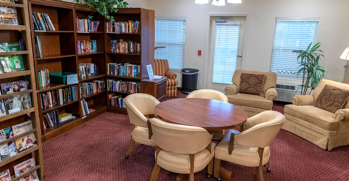 Cozy library lounge with bookshelves and comfortable seating.
