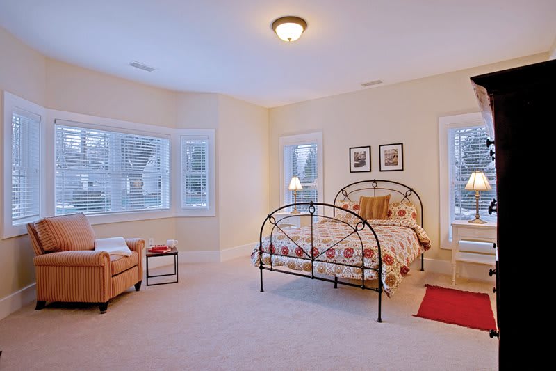 A cozy bedroom with a bed and large windows providing natural light.