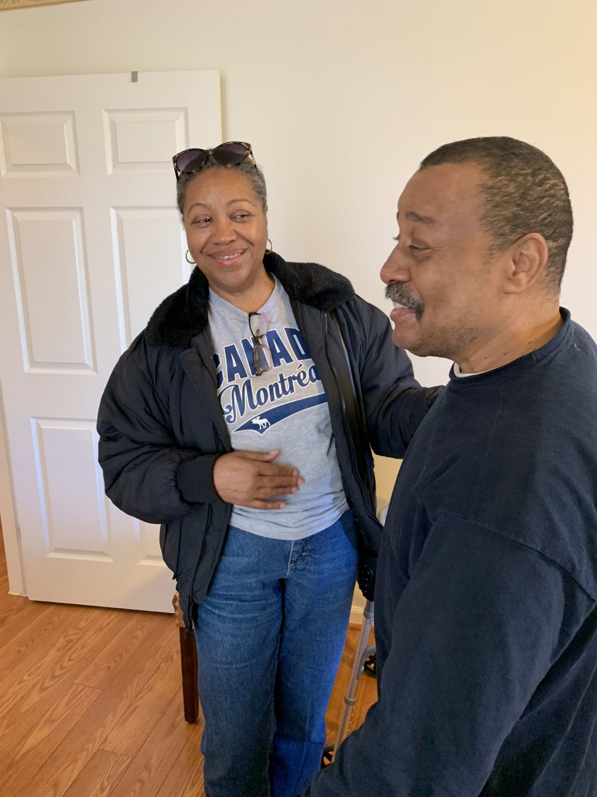 Two people smiling and interacting indoors.