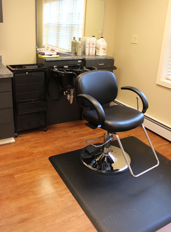An interior view of a hair salon, featuring a barber chair and salon equipment.