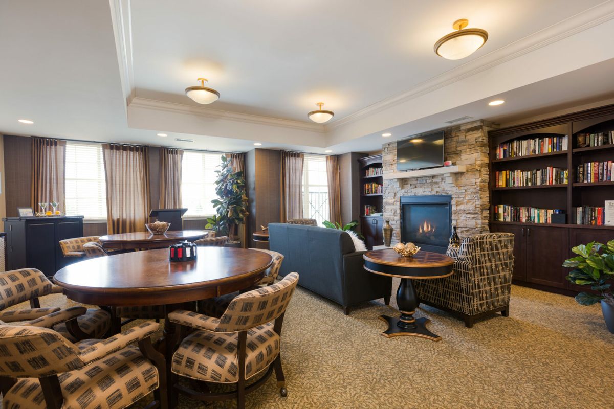 A cozy living room with a fireplace, bookshelves, and comfortable seating.