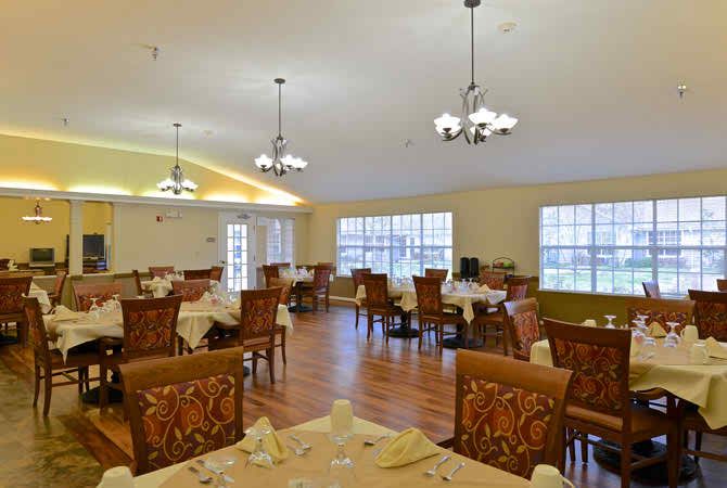 A spacious and elegantly decorated dining room with several tables and chairs set up for guests.