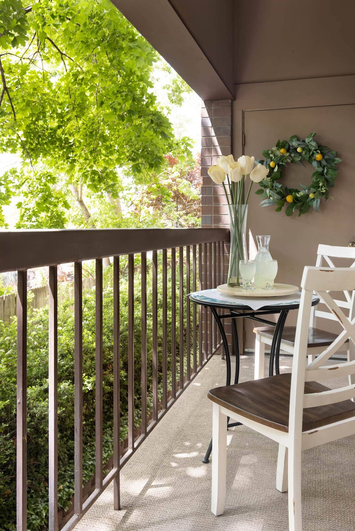 A cozy balcony with a small table, chairs, and decorative elements.