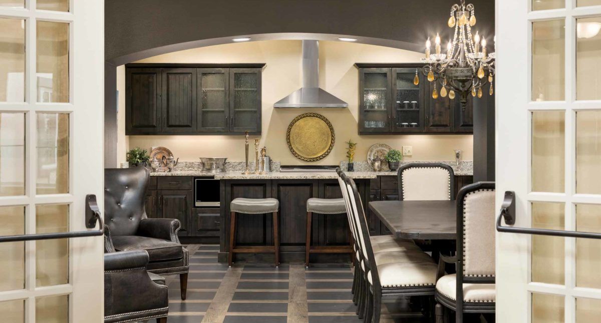 A modern kitchen with dark cabinets and a cozy dining area.