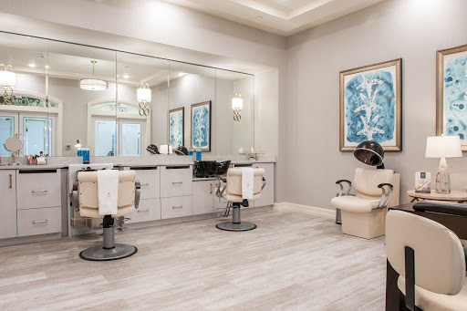 A modern hair salon featuring stylish chairs, ample lighting, and decorative wall art.