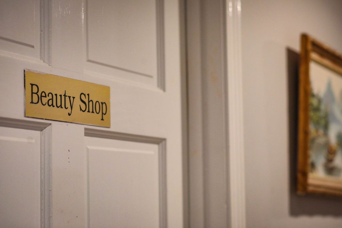 A door with a sign indicating a beauty shop.