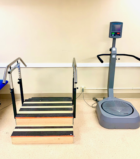 A rehabilitation area featuring a set of stairs and a vibration plate.