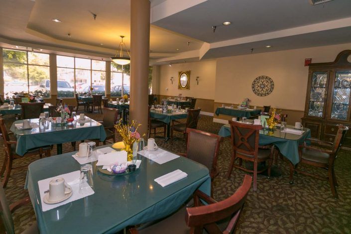 A cozy dining room with tables set for a meal.