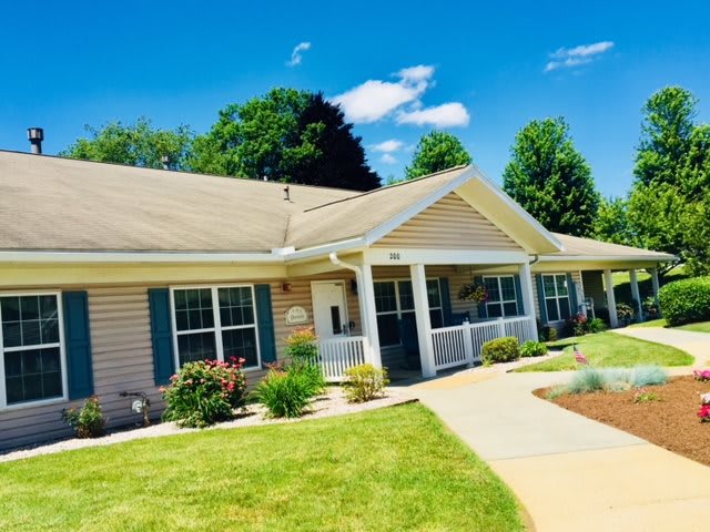A charming house with a well-maintained garden on a sunny day.