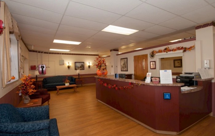 A hospital reception area with a desk, seating, and decorations.