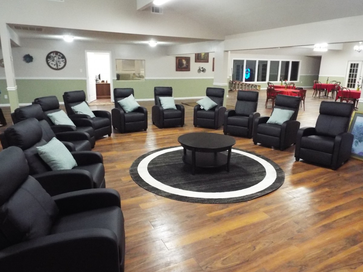 A spacious room with a circular arrangement of comfortable chairs surrounding a central table.