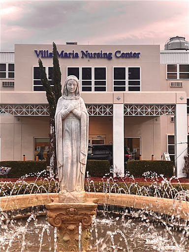 View of the Villa Maria Nursing Center featuring a serene fountain and statue.