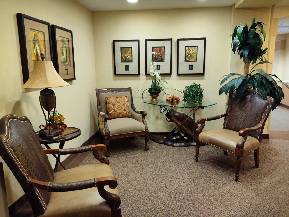 A cozy waiting room with classic furniture and framed artwork on the walls.