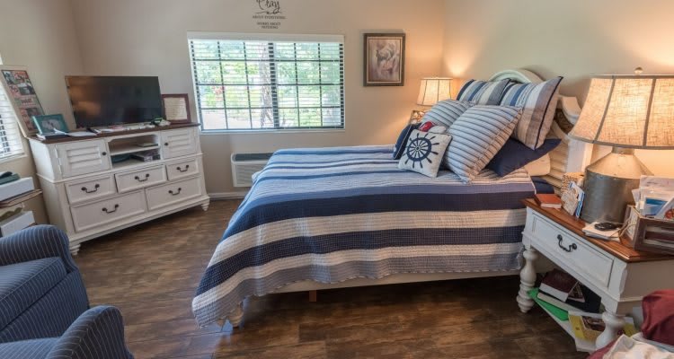 A cozy bedroom with striped bedding and a well-lit window.