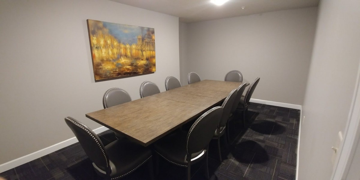 A modern conference room with a large wooden table, surrounded by chairs and featuring a decorative painting on the wall.