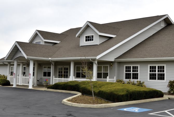 A modern building with a landscaped front and accessible parking space.