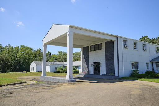 A modern architectural structure featuring prominent columns and a clear blue sky.