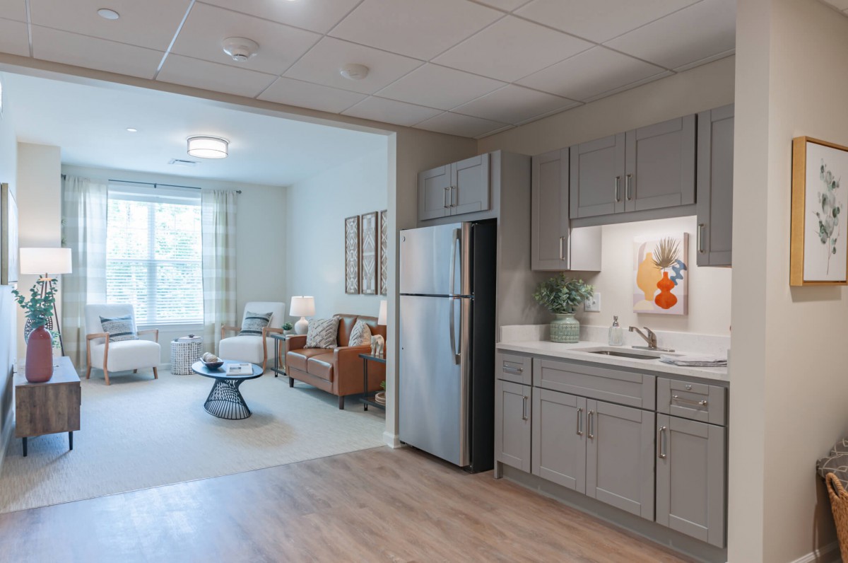 A modern apartment interior featuring an open-plan kitchen and living room with stylish furniture and decor.